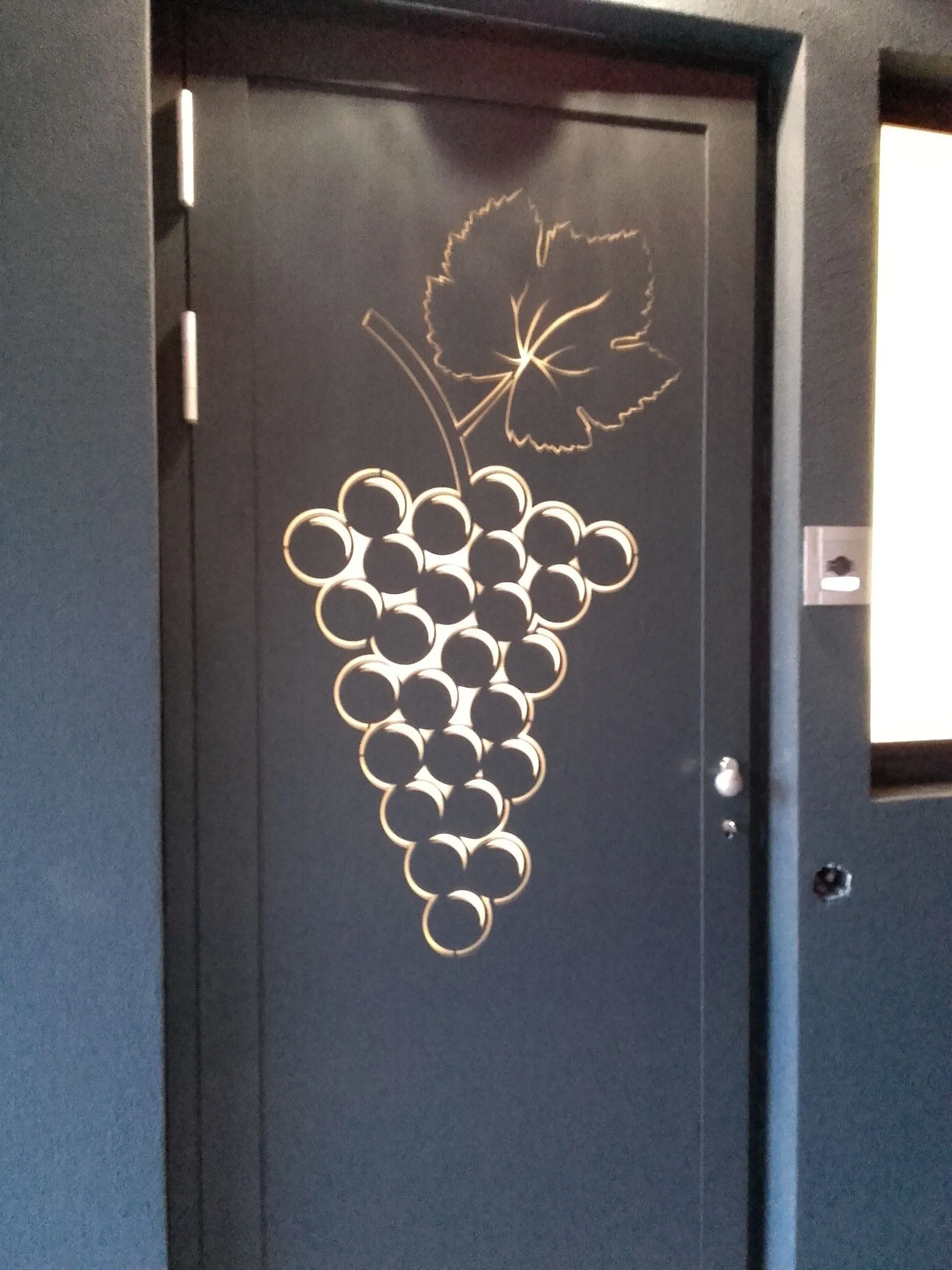 Porta blindata con decoro a grappolo d'uva traforato
